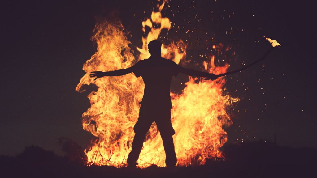 man standing in front of fire