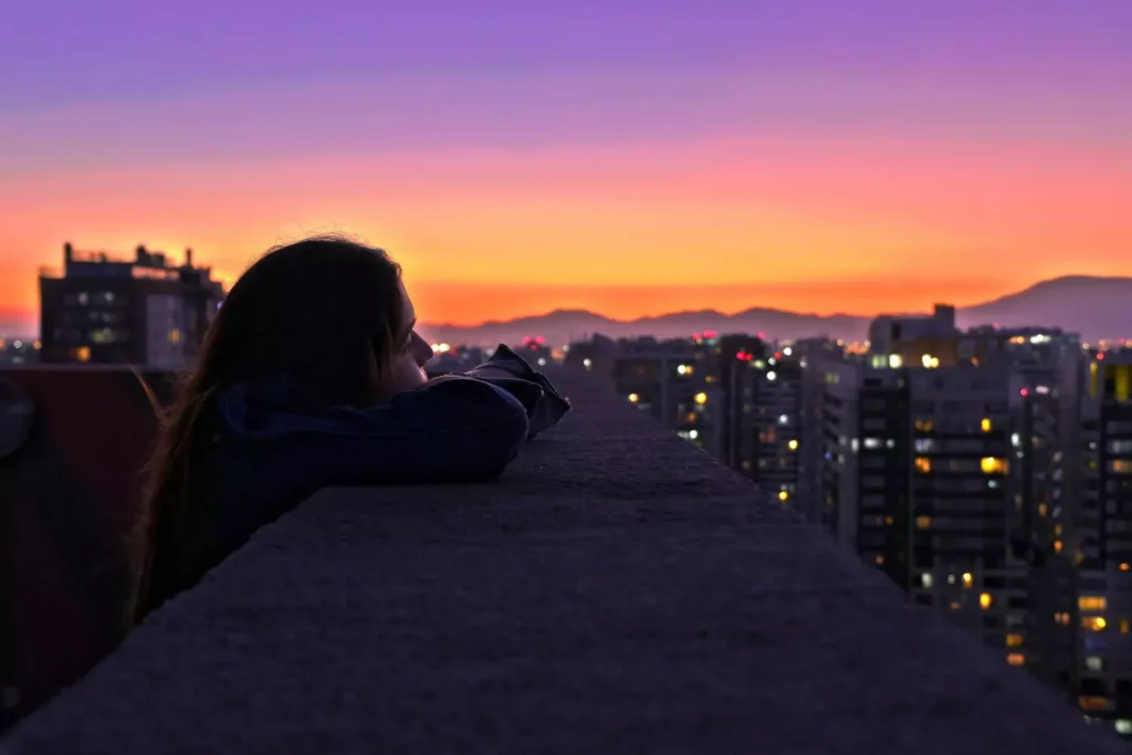 a woman giving God control of her failure, looking out at a sunset