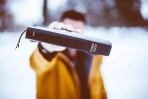 a tough Christian holding up his Bible